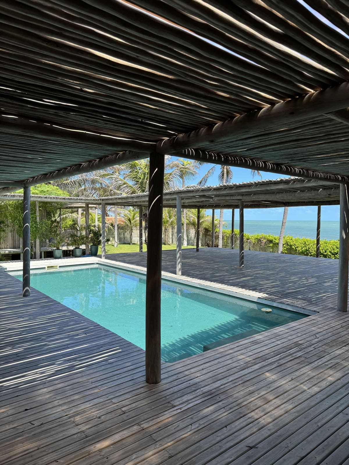 Residência beira-mar com piscina, deck e cobertura em bambu